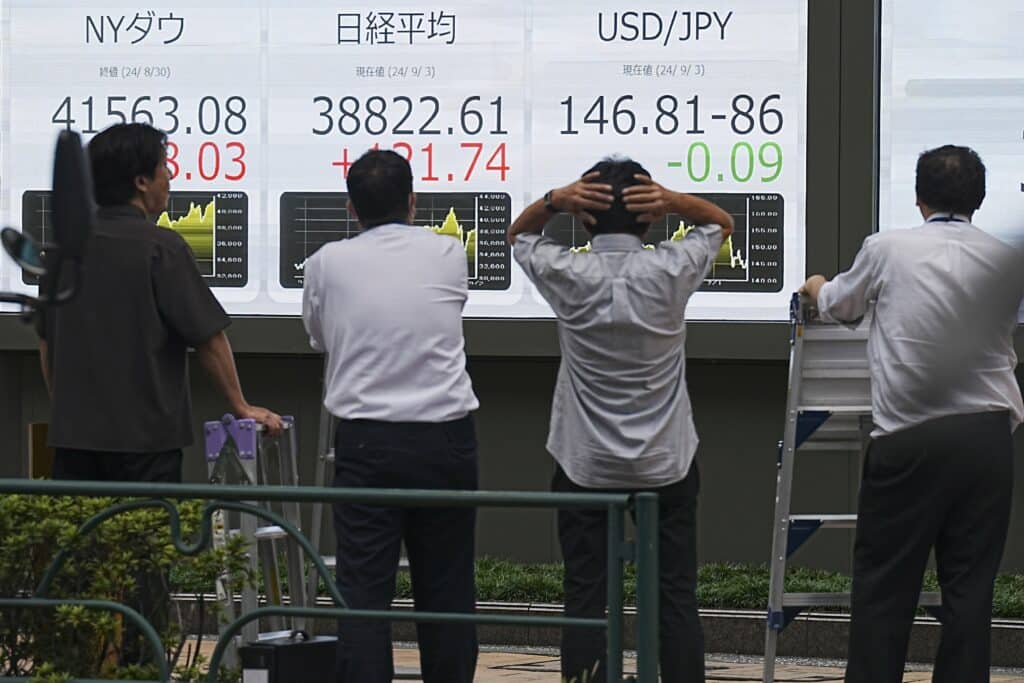 People look at an electronic stock board showing Japan's Nikkei index at a securities firm Tuesday, Sept. 3, 2024, in Tokyo.