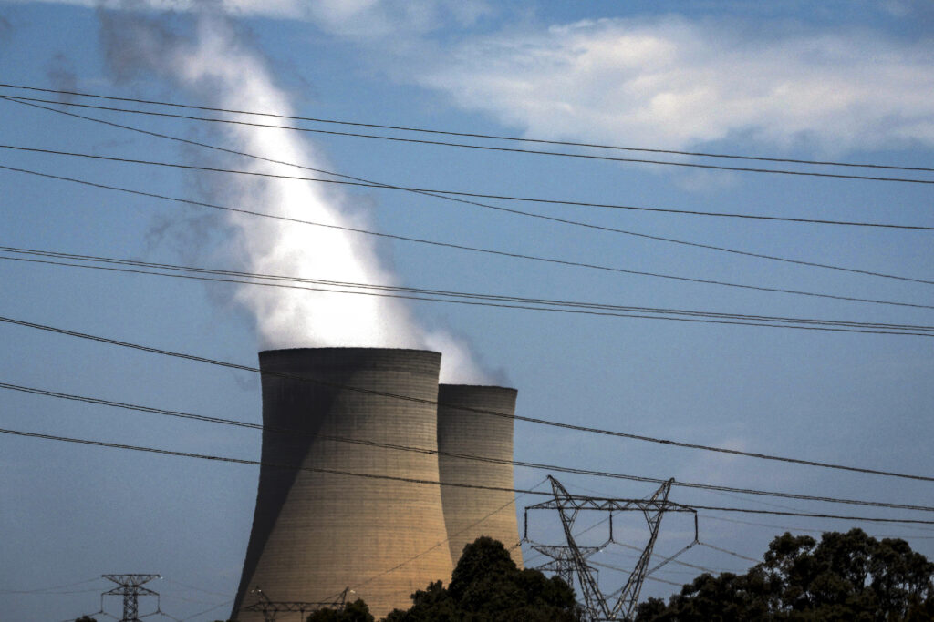 This photo taken on December 13, 2023 shows electricity lines passing near the emission funnels of the Bayswater coal-powered thermal power station near the central New South Wales town of Muswellbrook.