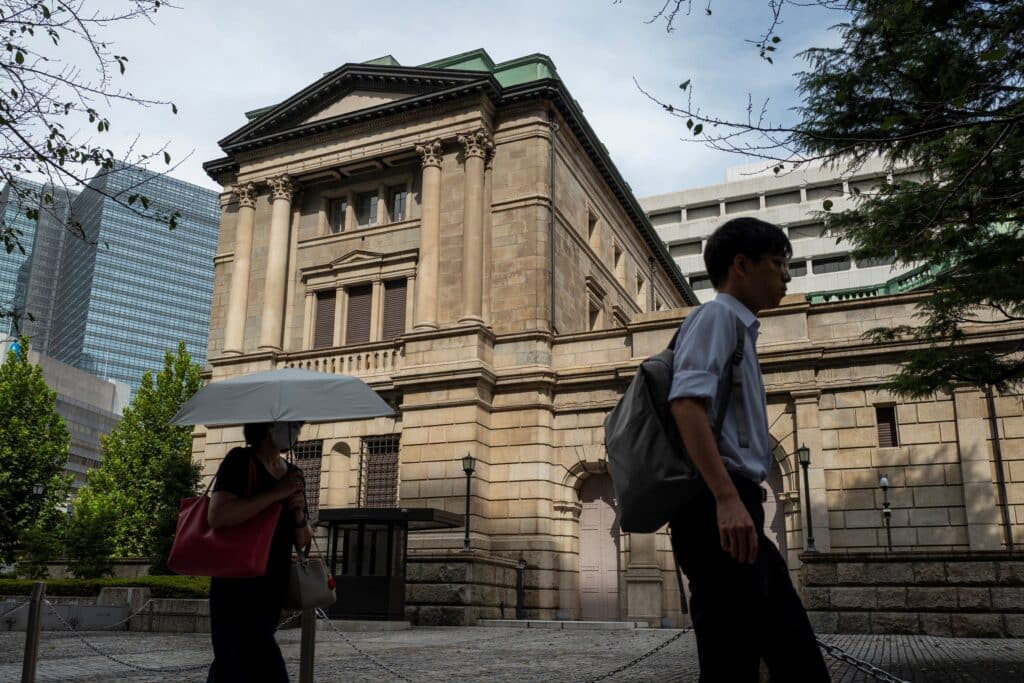 Pedestrians walk past the Bank of Japan headquarters in Tokyo on September 19, 2024. 