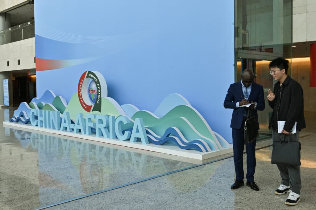 People stand next to a sign of the Forum on China-Africa Cooperation (FOCAC)