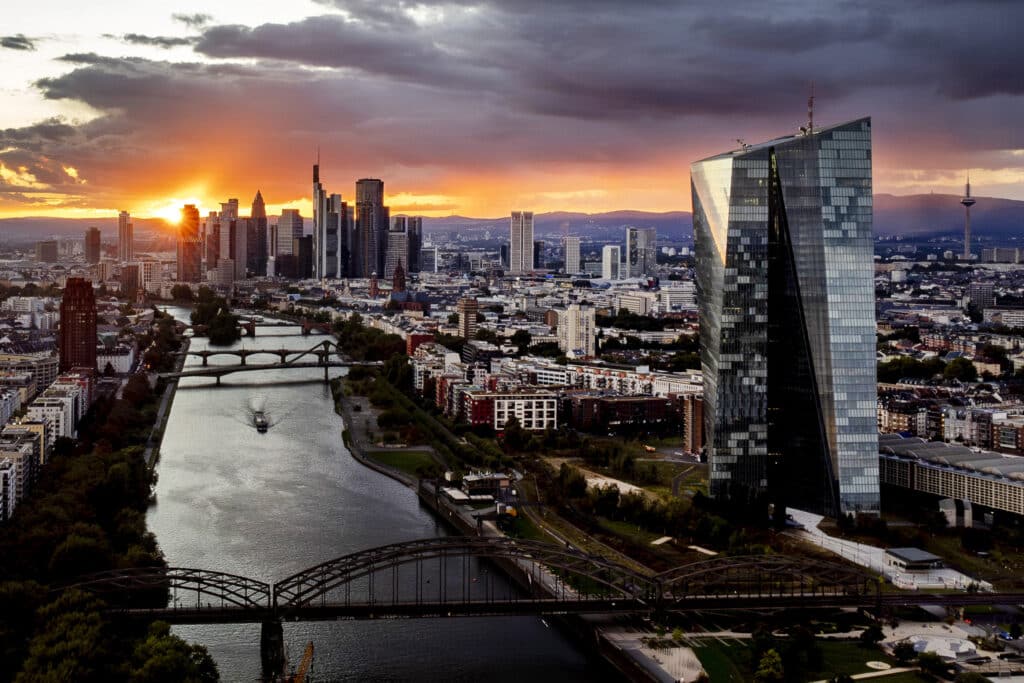 The sun sets over the buildings of the banking district, rear left, and the European Central Bank, front right, in Frankfurt, Germany, Wednesday, Sept. 11, 2024.