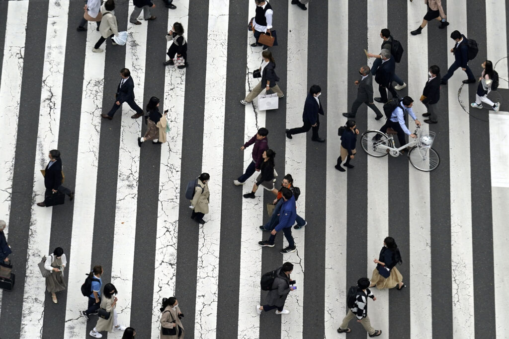 FILE - People walk along a pedestrian crossing at Ginza shopping street in Tokyo, on March 31, 2023, in Tokyo.