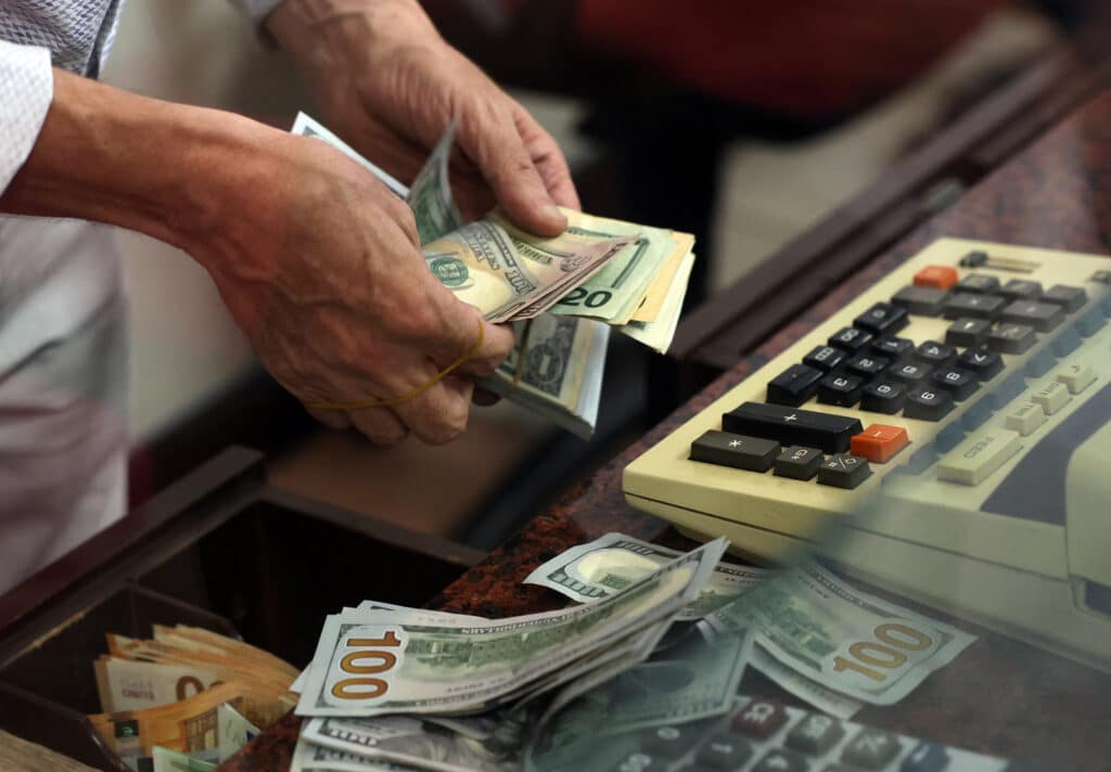 (FILES) A teller counts US dollar bills at an exchange office in Ankara on July 20, 2023.