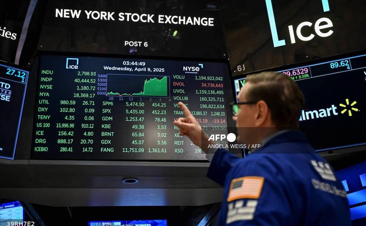 A trader points at stock data on a monitor at the floor of the New York Stock Exchange