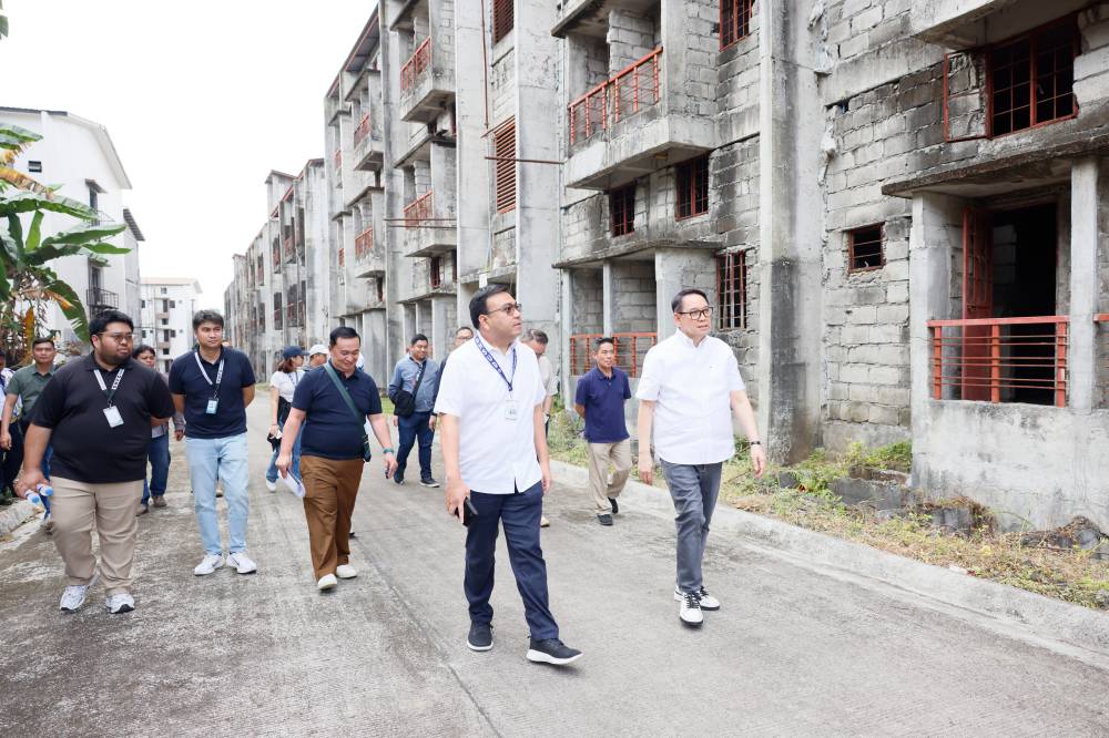 Secretary Jose Ramon Aliling and Social Housing Finance Corp. President and CEO Federico Laxa inspect long-stalled vertical housing projects in Caloocan City.