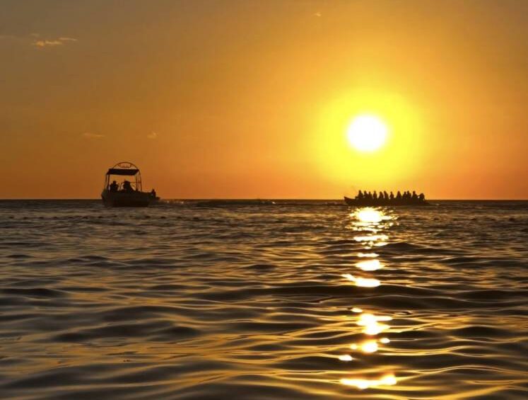 Boats glide across the waters of Puerto Galera as the sunset bathes the ocean in warm hues